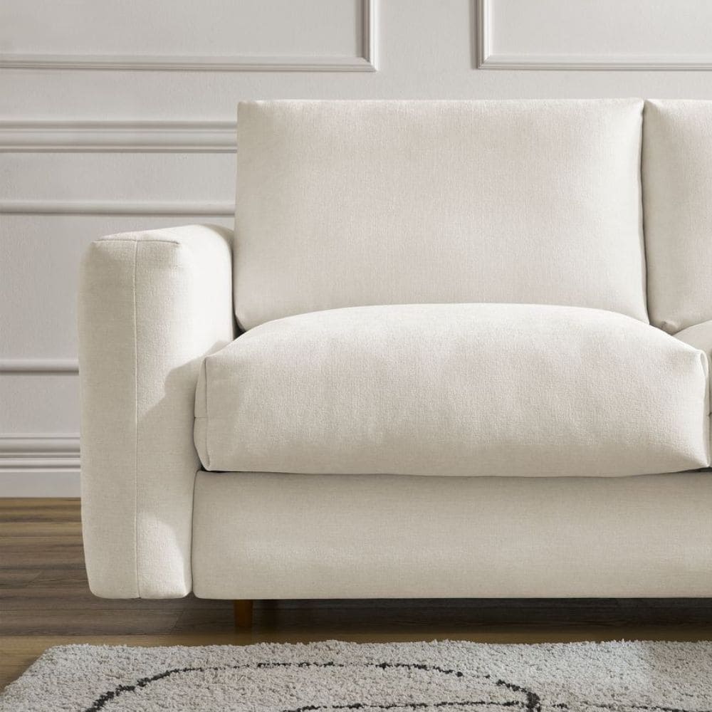 Canapé bas beige Cocoone Bobochic en tissu lisse dans salon avec beau tapis