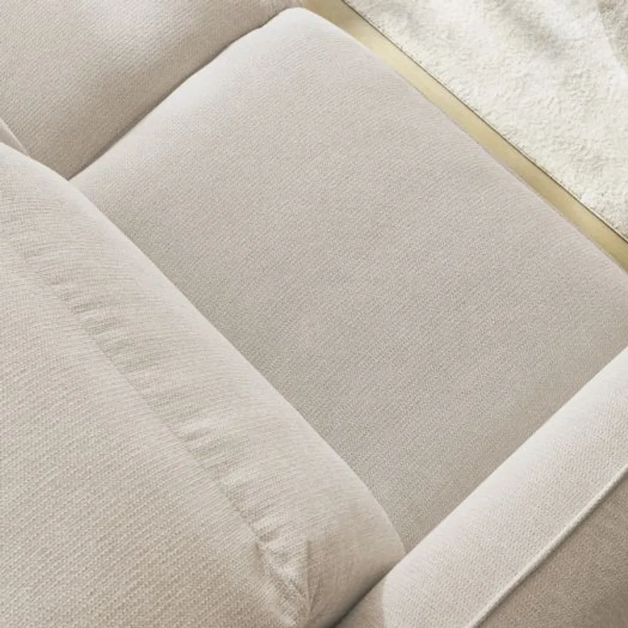 Gros plan des coussins et de la matière texturée beige du canapé Achille.