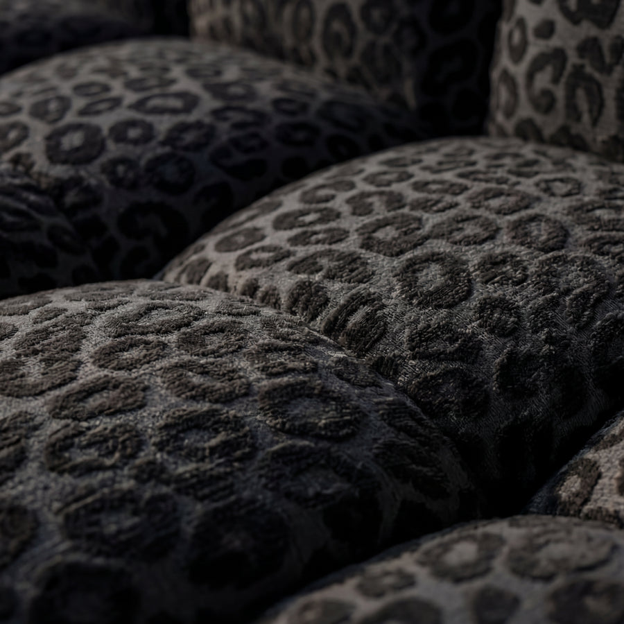 Détail en gros plan du tissu gris anthracite du canapé Alexia avec motif pointillé.