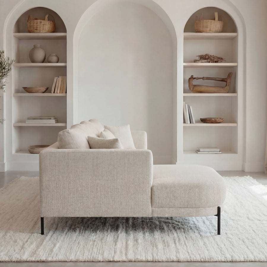 Canapé Bianca d'angle en beige dans un salon lumineux avec étagères arrondies.