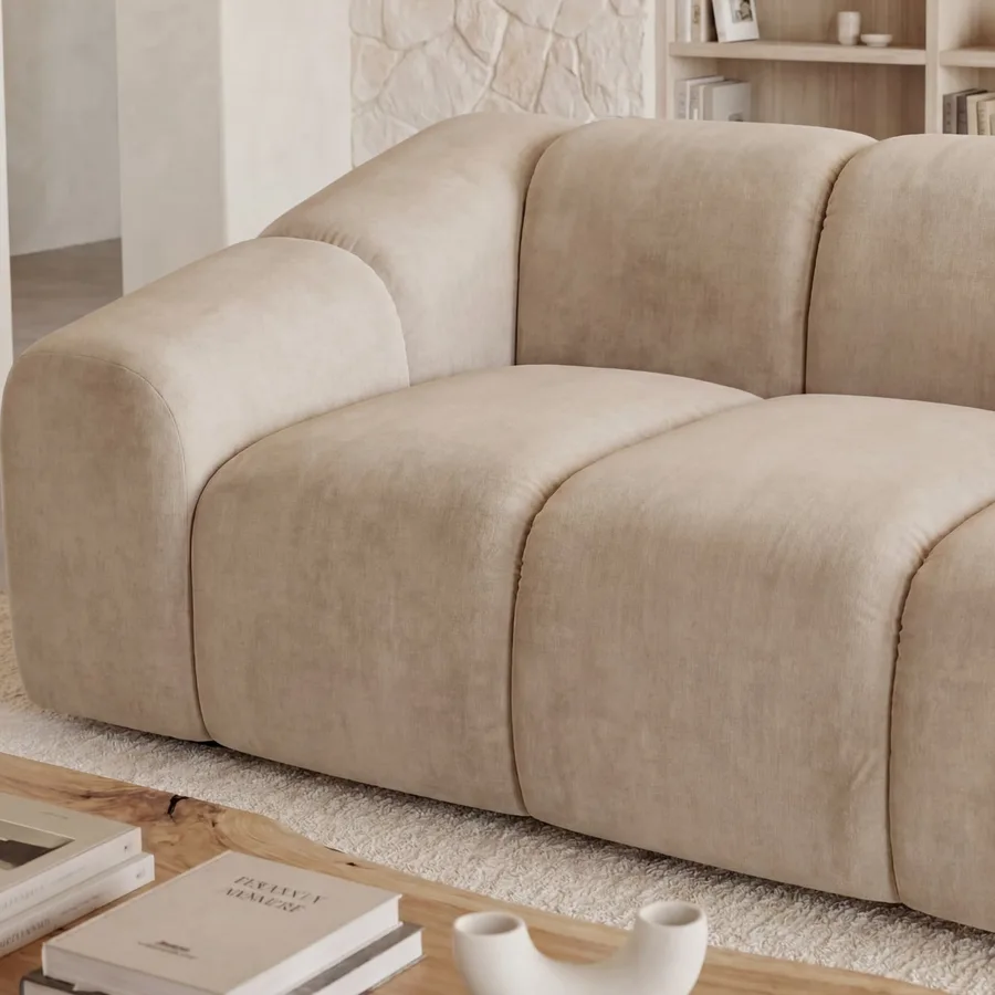 Gros plan des coussins gonflés et de la matière beige du canapé Candice