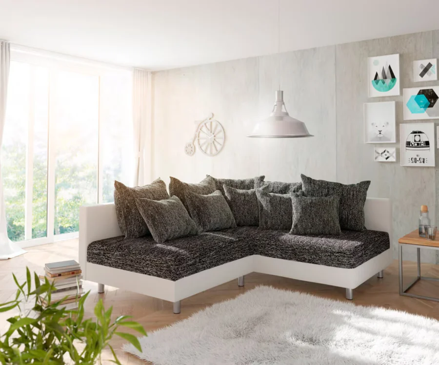 Canapé Clovis d'angle en tissu anthracite chiné et simili cuir blanc, dans un salon lumineux.