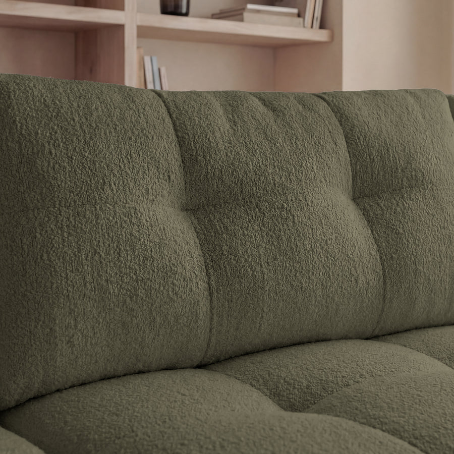 Détail des coussins et des quilting du dossier du canapé Constance en tissu vert.
