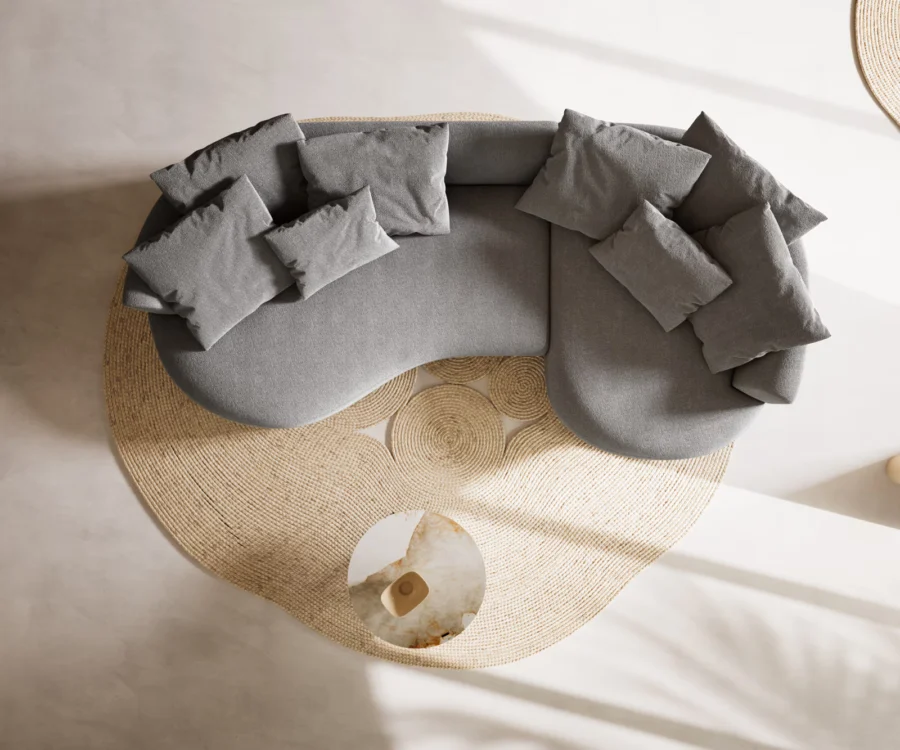 Vue de dessus du canapé gris clair en forme de demi-lune, coussins sur l'assise.
