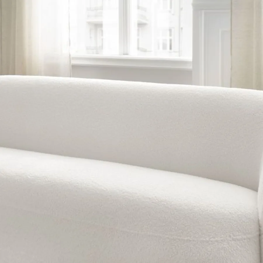 Gros plan sur l'accoudoir et le coussin du canapé Elina blanc.