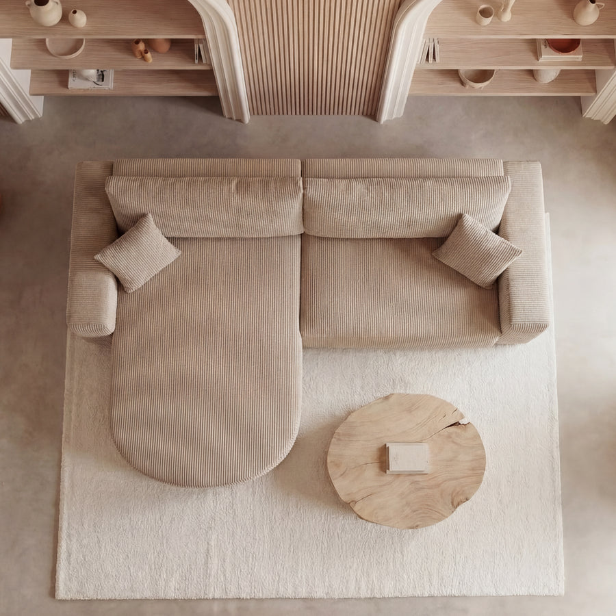 Vue aérienne du canapé Emma d'angle beige avec méridienne arrondie et table basse ronde