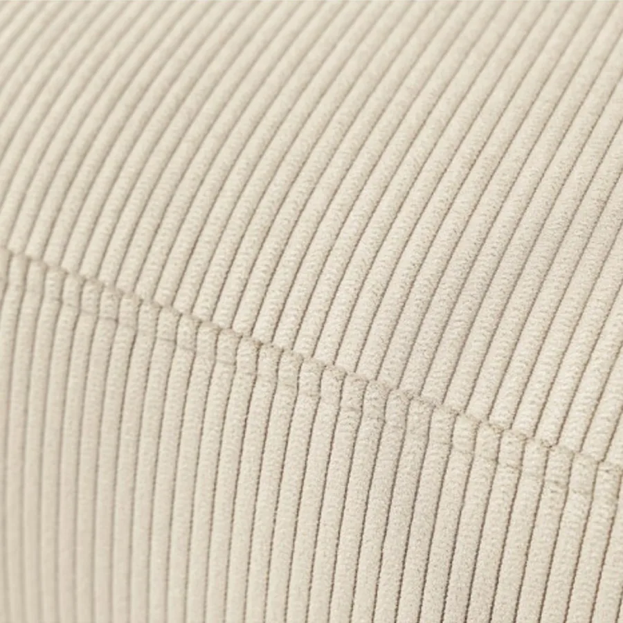 Gros plan de la matière velours côtelé crème, texture nervurée du tissu visible