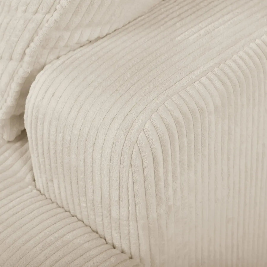 Détail du tissu côtelé crème et couture de l'accoudoir du canapé Faustine.