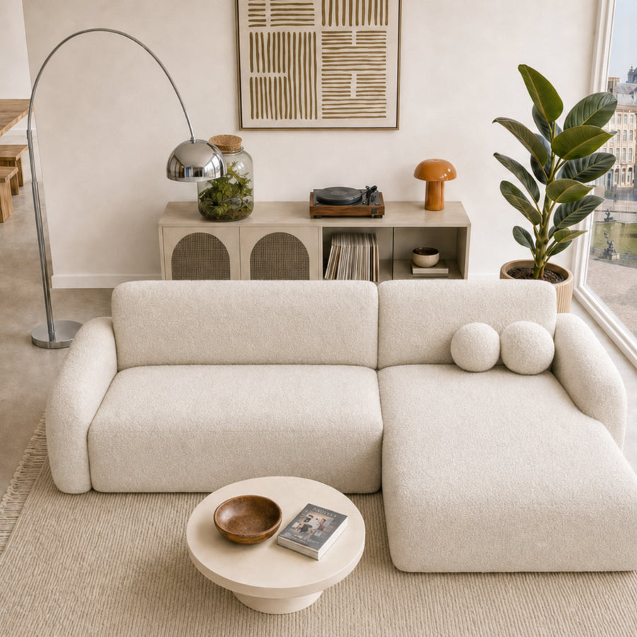 Canapé Gigi angle beige avec rangement mural derrière, salon contemporain lumineux