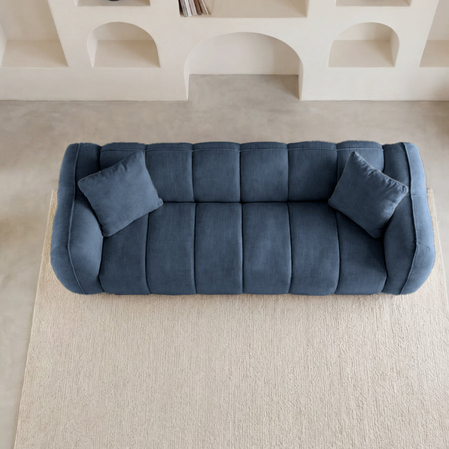 Vue aérienne du canapé Havana bleu avec coussins, tapis beige et décoration autour