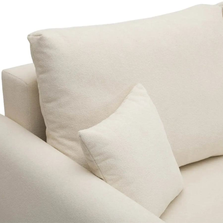 Gros plan sur les coussins et le revêtement en tissu beige du canapé Hera.
