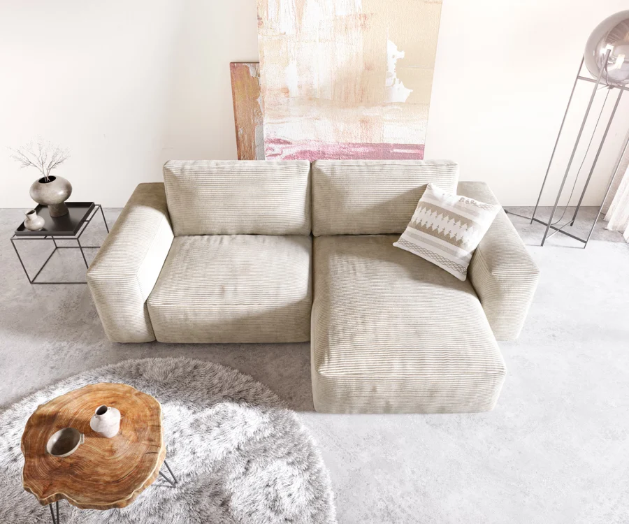 Vue de dessus du canapé d'angle beige côtelé avec méridienne à droite et coussin.