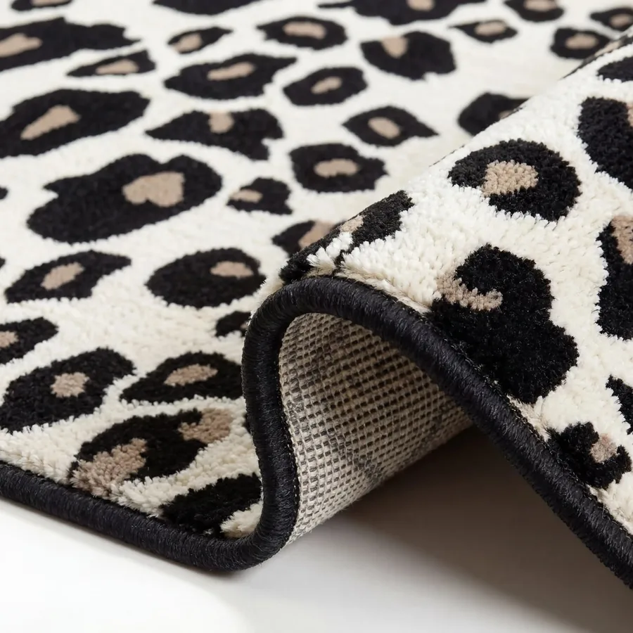 Gros plan du tapis animalier léopard montrant le revers et les finitions noires