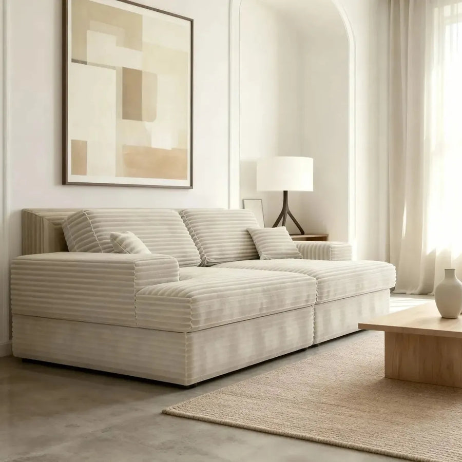 Canapé Lisbonne XL beige clair en tissu rayé dans un salon blanc avec mobilier en bois naturel.