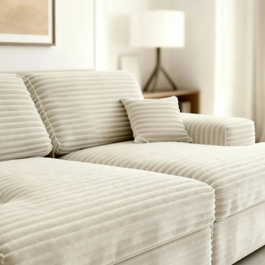 Gros plan sur les coussins et la texture striée du tissu beige du canapé Lisbonne.