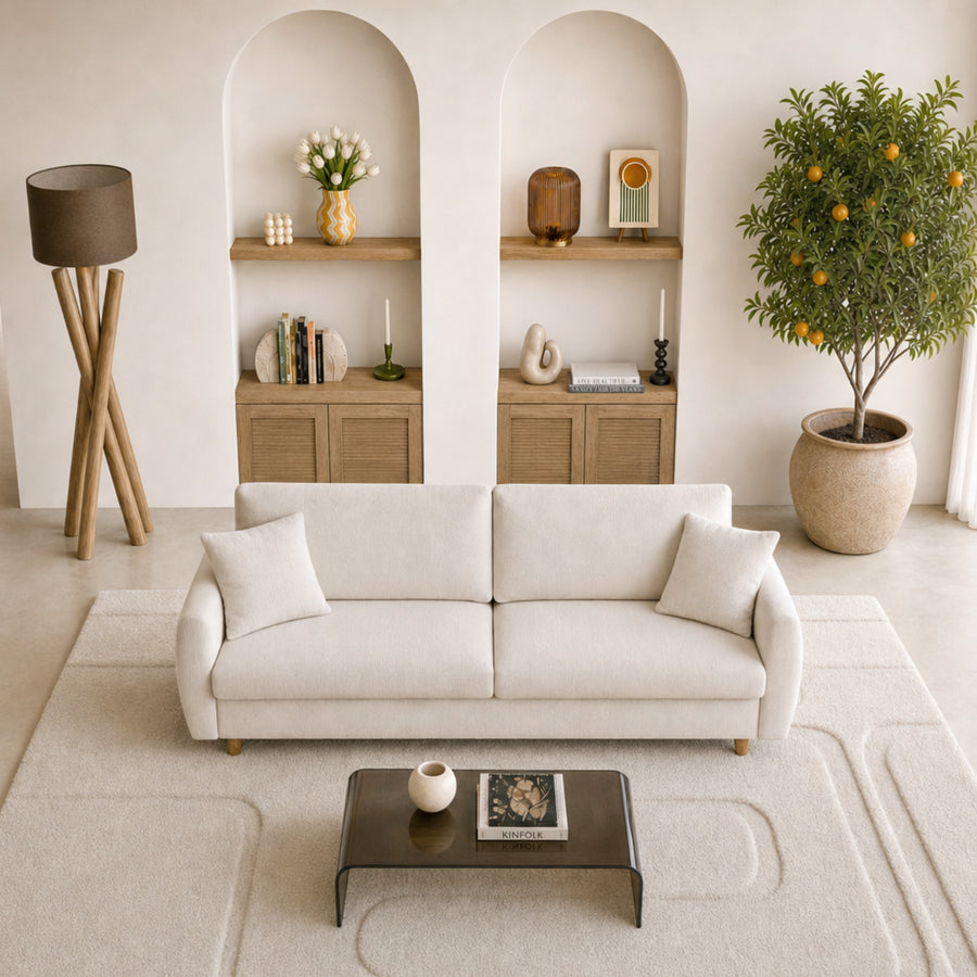 Canapé Lumie beige dans salon blanc, vue de dessus avec vue mer par baies vitrées.