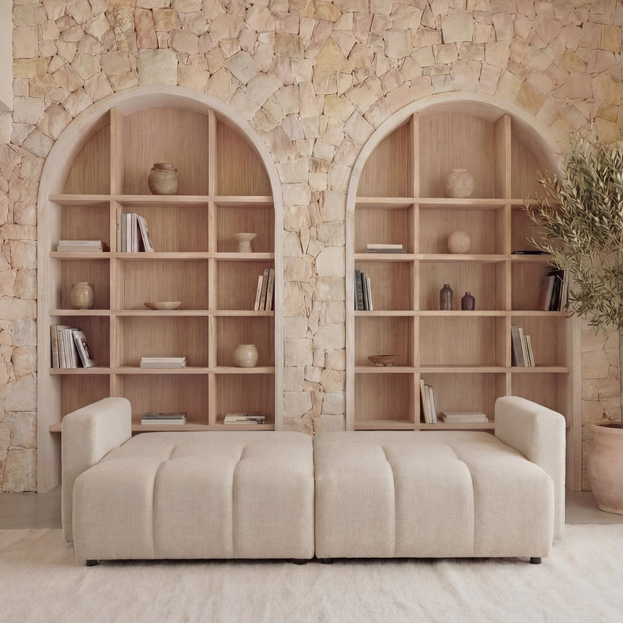 Canapé Maia beige deux places face, assise bombée avec niches bois et pot terre cuite.