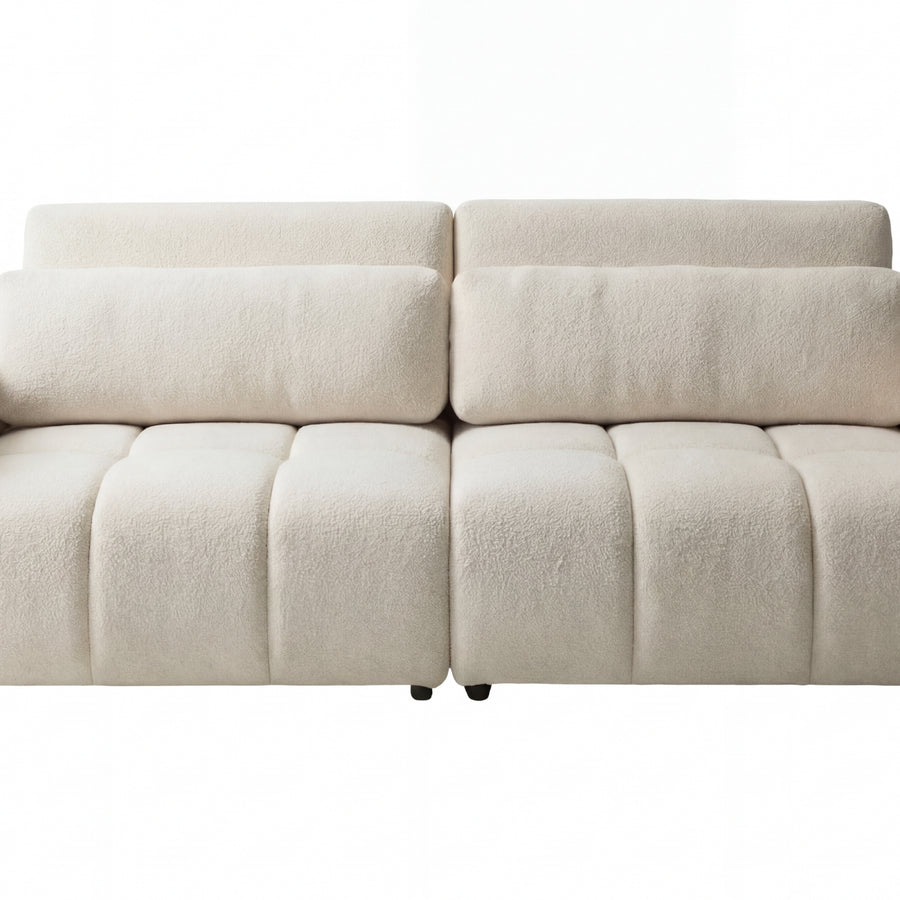 Canapé Maia beige clair en cuir, six sections capitonnées, accoudoirs bas et arrondis.
