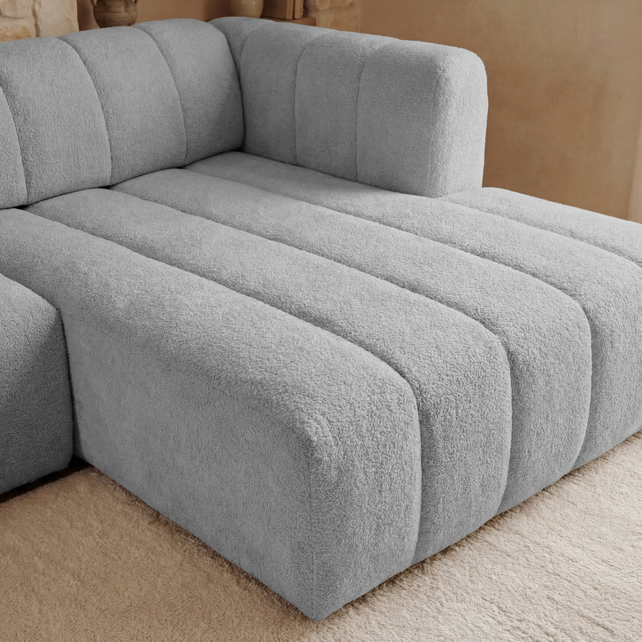 Gros plan sur la méridienne du canapé Marius montrant les coutures et le tissu gris