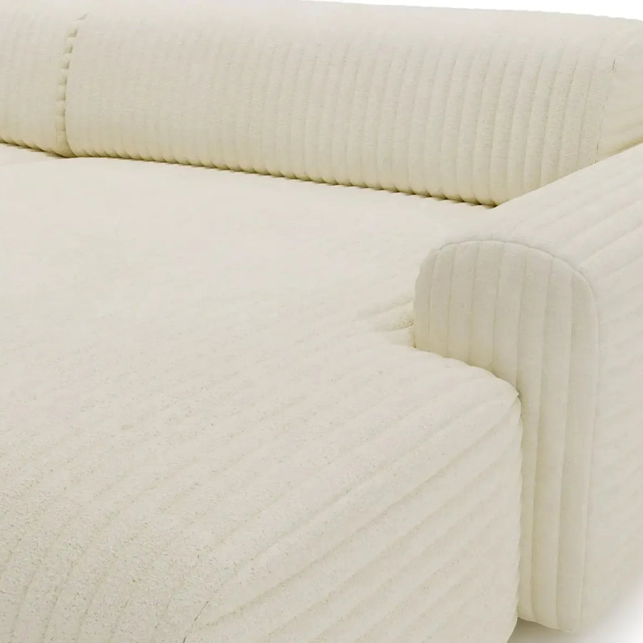 Gros plan du revêtement beige du canapé Mila, texture rayée et coutures visibles
