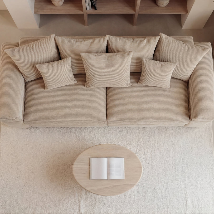 Vue de dessus du canapé Octave beige avec coussins et table basse ovale.
