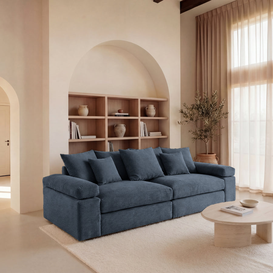 Canapé Octave bleu foncé en tissu dans un salon lumineux avec arche architecturale.