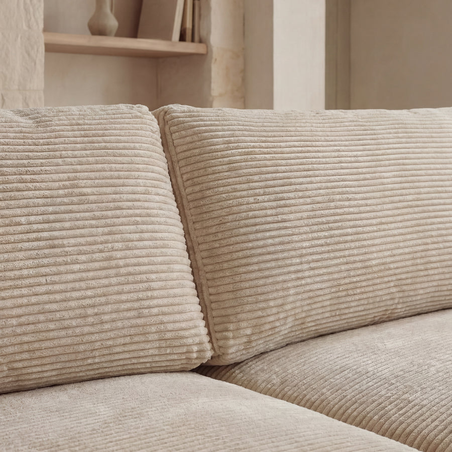 Détail des coussins et accoudoirs du canapé Olympe en tissu beige côtelé