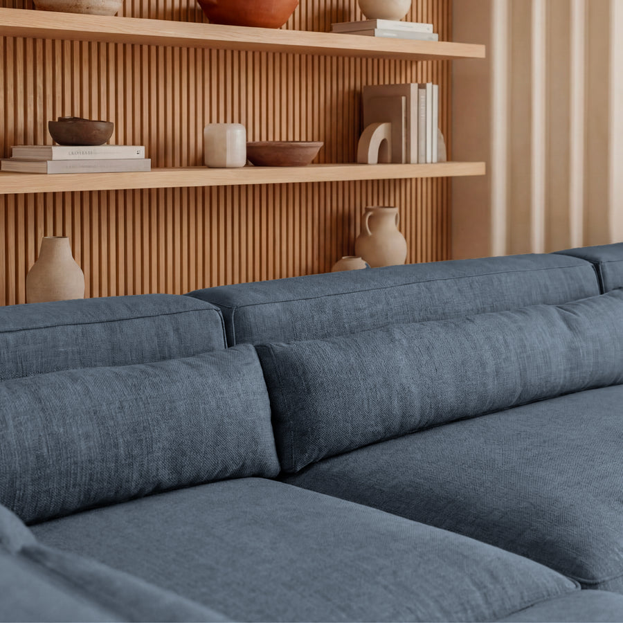 Gros plan des coussins et de l'assise du canapé Pablo en tissu bleu gris.