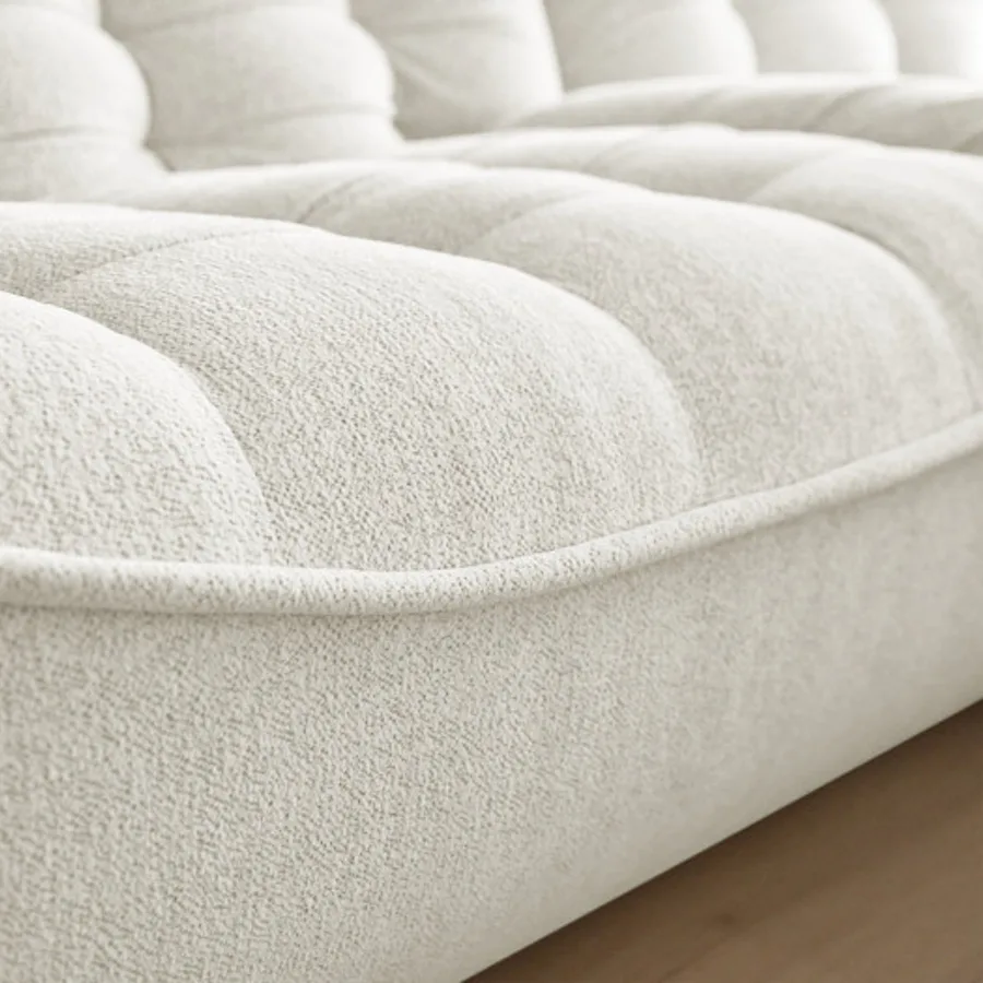 Détail de la matière en tissu blanc crème du canapé Serena avec ses coutures.