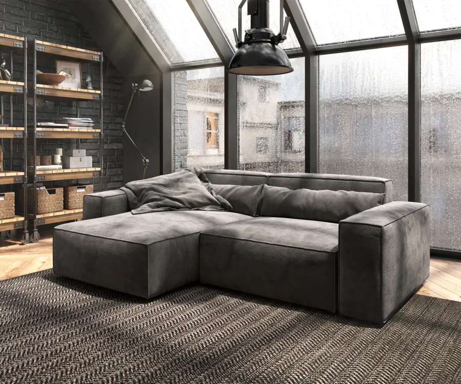 Canapé d'angle gris foncé avec méridienne à gauche dans un loft industriel au style sombre