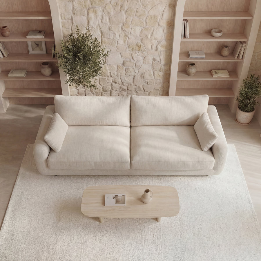 Vue de dessus du canapé Stella beige dans le salon avec rangements et plantes.