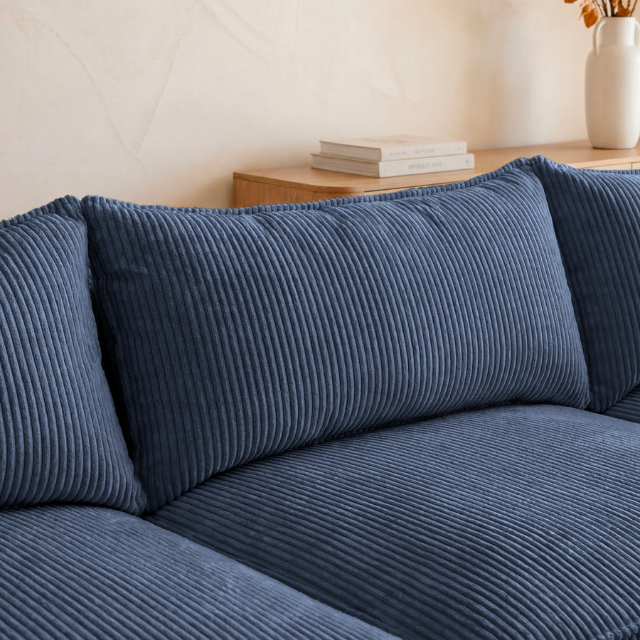 Gros plan des coussins côtelés bleu du canapé Suzanne, matière en relief.
