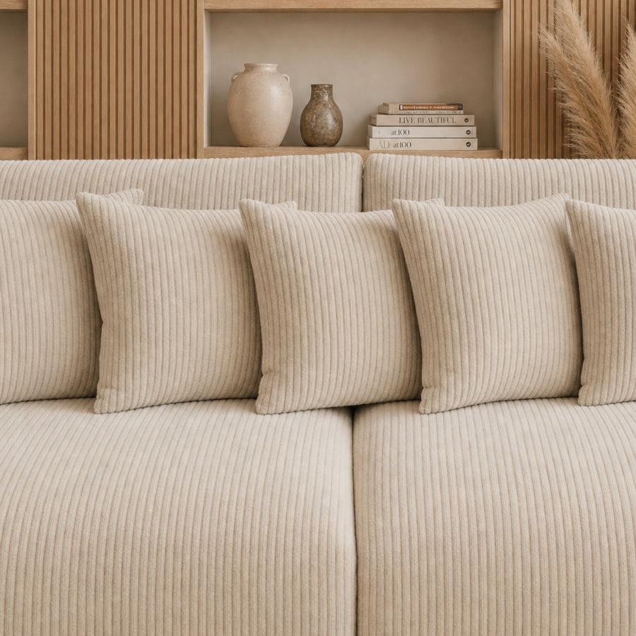 Détail des coussins alignés sur le canapé Suzie en velours côtelé beige