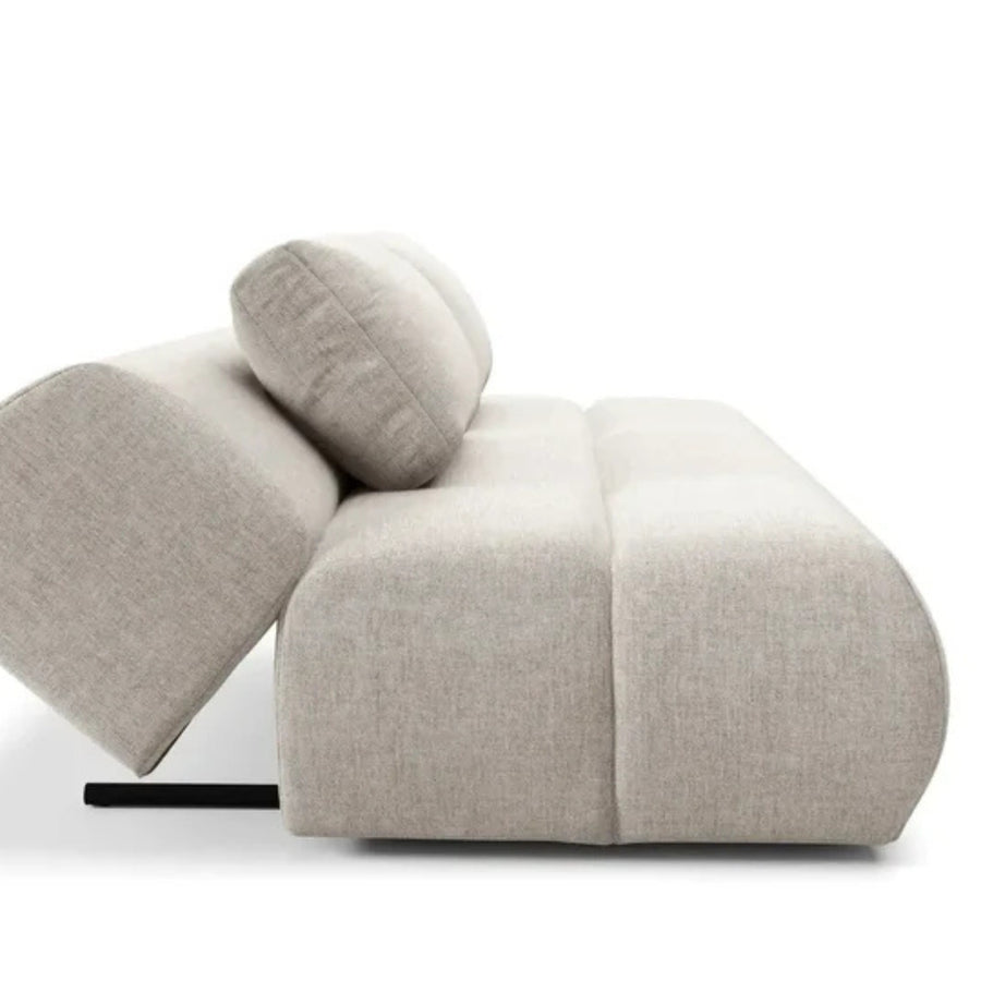 Détail des coussins arrondis du canapé Tina en tissu gris clair.