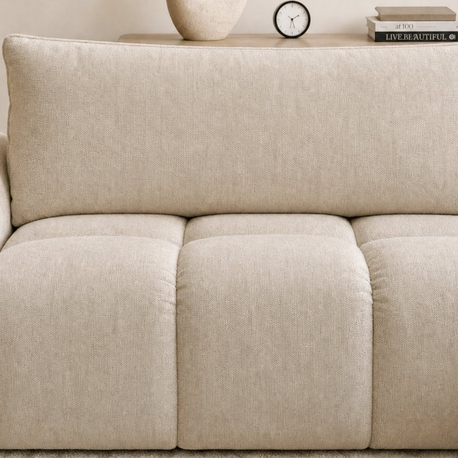 Gros plan du Canapé Viana en tissu crème montrant les détails des coussins rembourrés et des accoudoirs.